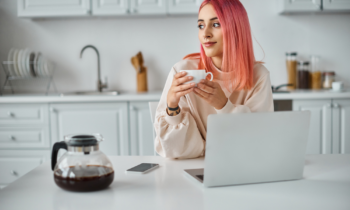 Attractive jolly woman with pink hair in casual attire reading an Amazon MTurk Review